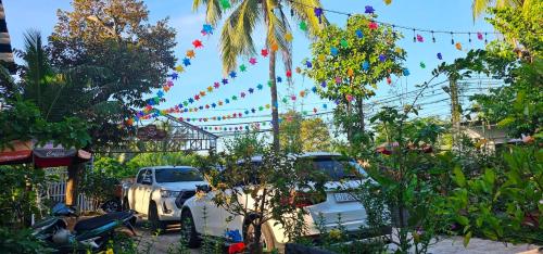 a group of cars parked in a yard with flags at Dak Nguyen Homestay DakLak in Dak Lak