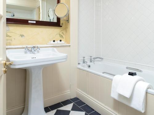 a bathroom with a sink and a bath tub at Meadowlands Hotel in Tralee