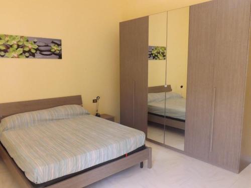 1 dormitorio con cama y armario con espejo en Appartamento La Dimora Siciliana, en Trapani