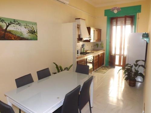 una cucina con tavolo bianco e frigorifero bianco di Appartamento La Dimora Siciliana a Trapani