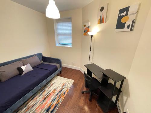 a living room with a blue couch and a table at Unique Three bedroom w/ workspace in Brooklyn