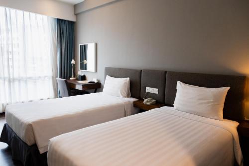 a hotel room with two beds and a window at WP Hotel in Kuala Lumpur