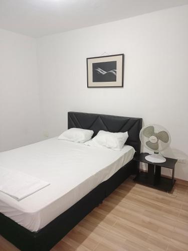 a bedroom with a bed with a black headboard at Apartamento Amoblado en Ibague in Ibagué