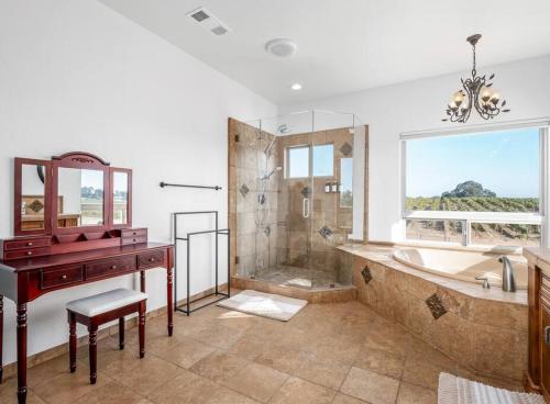 a bathroom with a tub and a sink and a desk at Luxury 4 Acre Estate - Pickleball, Pool, Hot Tub! in Lockeford