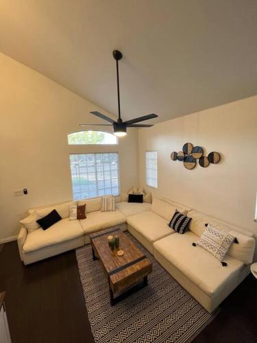 a living room with couches and a ceiling fan at CasAHermosa Cozy getaway ! in Las Vegas