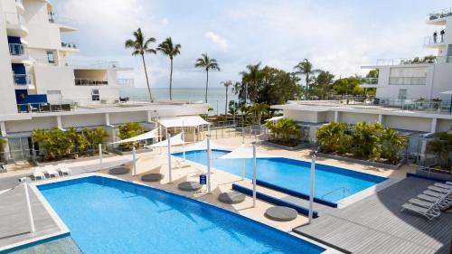 an aerial view of a hotel with a swimming pool and the ocean at Oaks Hervey Bay Resort and Spa in Hervey Bay