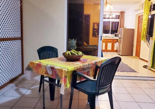 a dining room table with a bowl of fruit on it at Studio Iti Fare Tepua Lodge in Uturoa