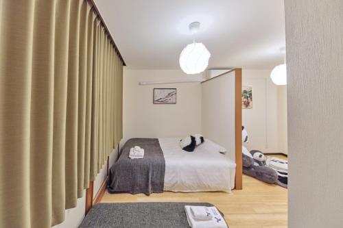 a bedroom with a bed and a large window at TORA HOTEL Tokyo Ueno 寅ホテル 上野 B in Tokyo