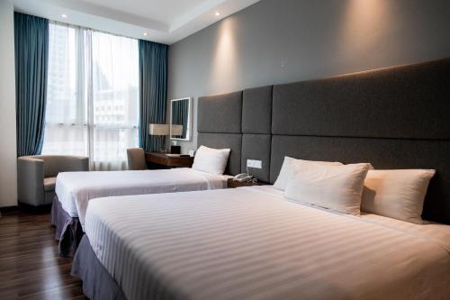 a hotel room with two beds and a large window at WP Hotel in Kuala Lumpur