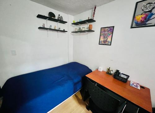 a bedroom with a blue bed and a desk at Habitaciones Saturno o Jupiter in Mexico City