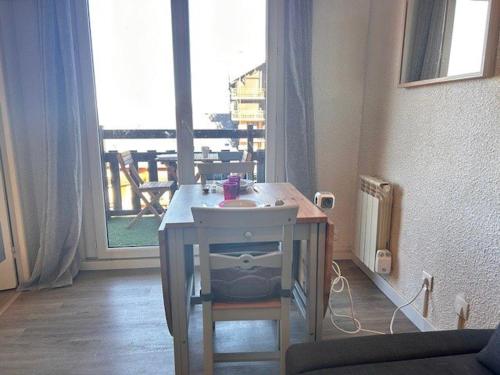 - une petite table dans une chambre avec une grande fenêtre dans l'établissement Studio Cabine 4 pers. à Risoul 1850, Accès Direct Pistes, Balcon, Piscine Chauffée l'Été - FR-1-330-575, à Risoul