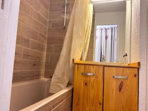 ein Badezimmer mit einer Badewanne, einem Waschbecken und einem Spiegel in der Unterkunft Appartement Risoul, 1 pièce, 4 personnes - FR-1-330-575 in Risoul