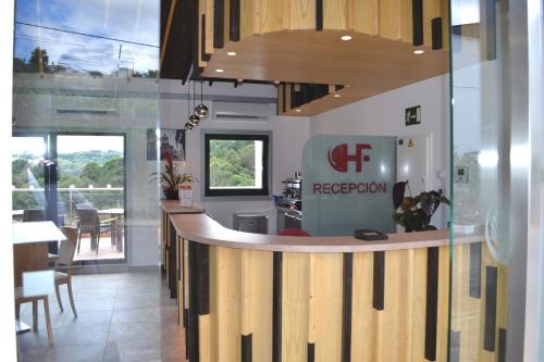 a restaurant with a reception counter in a room at Hotel Ferramenteiro de Portomarin in Portomarin