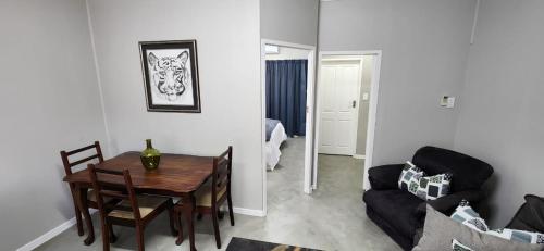 a living room with a table and a couch at Cottage Rose in Bloemfontein