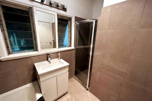 a bathroom with a sink and a shower at Maryborough Central Home in Maryborough