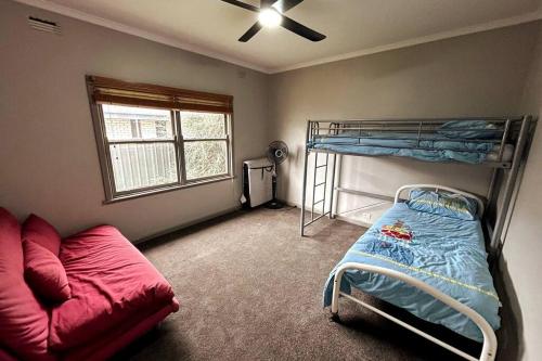 a bedroom with a bunk bed and a couch at Maryborough Central Home in Maryborough
