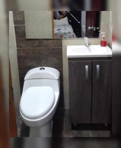 y baño con aseo blanco y lavamanos. en VIVENTO Habitaciones Lujosas Estrato 6 Frente Campanario en Popayán