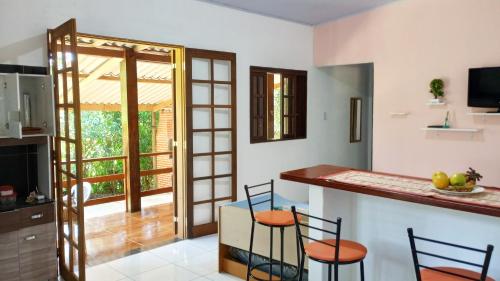 a kitchen with a counter and chairs in a room at Cantinho do Sossego - Sertão da Praia da Fazenda in Ubatuba