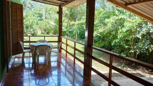 a porch with a table and chairs on it at Cantinho do Sossego - Sertão da Praia da Fazenda in Ubatuba