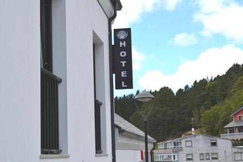 a sign for a hotel on the side of a building at Hotel Ferramenteiro de Portomarin in Portomarin