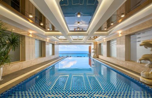 a swimming pool in a hotel with a view of the ocean at BlueSun Danang Beach Hotel in Da Nang