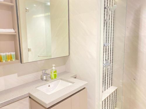 a white bathroom with a sink and a shower at Eaton Residences at Leo in Kuala Lumpur