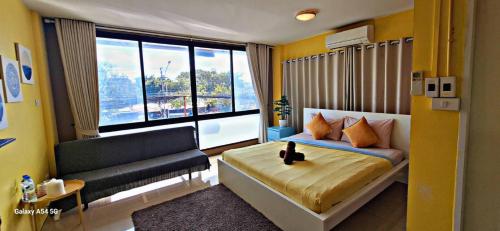 um quarto com uma cama, um sofá e uma janela em Peony's Home em Ban Don Muang (1)