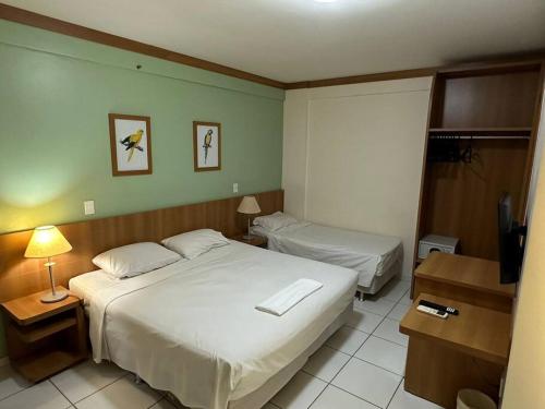 um quarto de hotel com duas camas e uma televisão em Golden Dolphin GRAND HOTEL - Apartamento COM VISTA em Caldas Novas