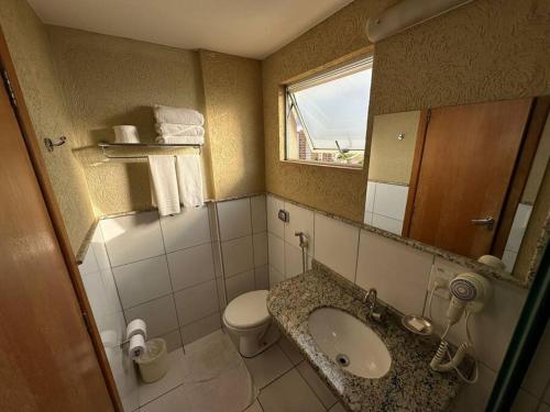 uma casa de banho com um lavatório, um WC e um espelho. em Golden Dolphin GRAND HOTEL - Apartamento COM VISTA em Caldas Novas