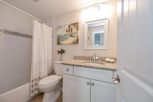 uma casa de banho branca com um WC e um lavatório em Coconut Cottage #1 em Holmes Beach