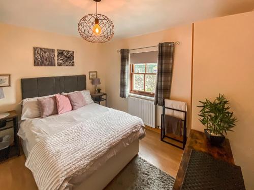 a bedroom with a bed and a potted plant at Apple Tree Cottage in Threlkeld