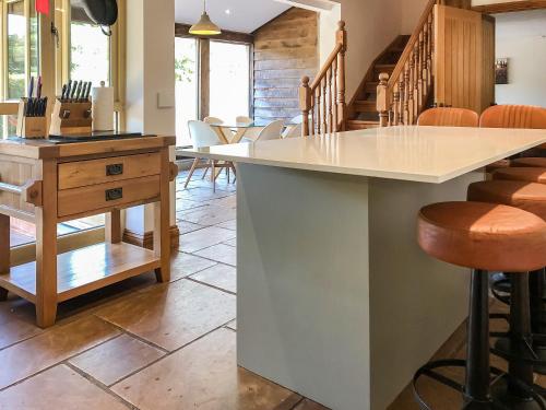 a kitchen with a counter and some chairs at Beer Farm in Stawley