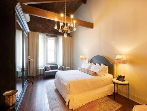 a bedroom with a large bed and a chandelier at Hotel Cleo Knoxville in Knoxville