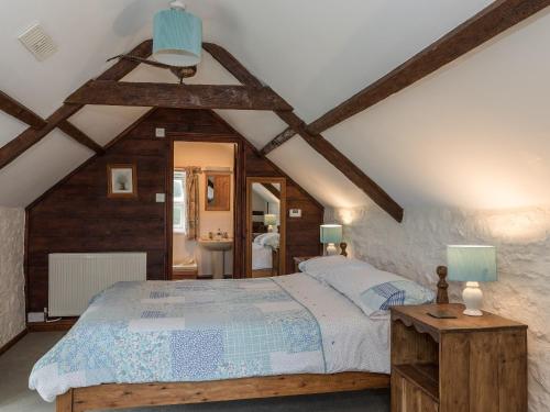 a bedroom with a large bed in a attic at Park Farmhouse in Chideock