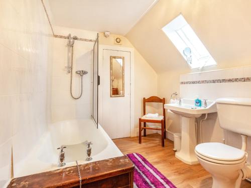 a bathroom with a shower and a toilet and a sink at Isla Bank Cottage in Keith
