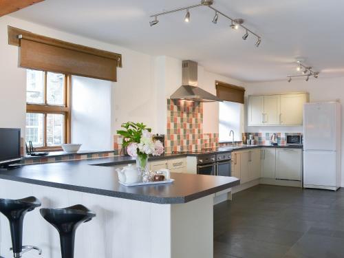 a large kitchen with a large island with flowers on it at Polmear Barn in Camelford