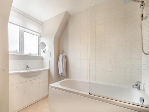 a white bathroom with a tub and a sink at The Mill Lodge in Malmesbury