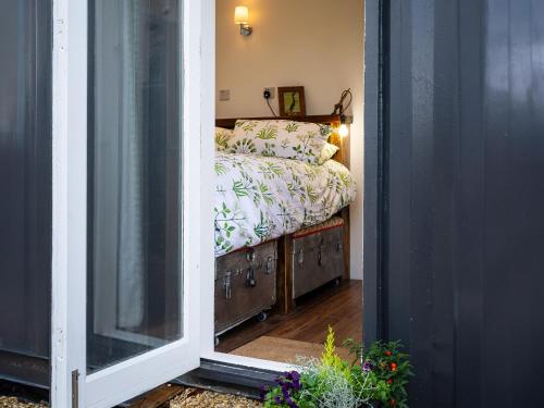 a bedroom with a bed in a room with a window at Sunrise Cabin in East Ilsley