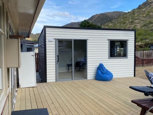 a small shed with a blue bag sitting on a deck at Cosy 1960's Kiwi Holiday House in Omarama