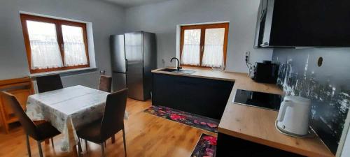 a kitchen with a table and a stainless steel refrigerator at Karolingerweg in Lauterhofen