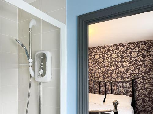 a mirror in a bathroom next to a bed at Royal House in Ilkeston