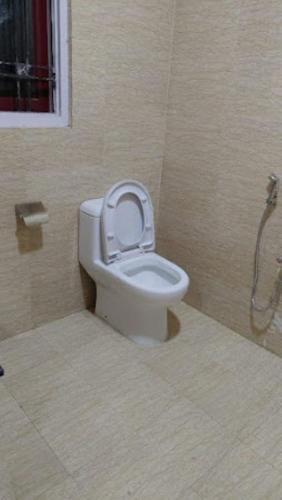 a bathroom with a toilet with the seat up at Mulberry Guesthouse Guwahati in Guwahati