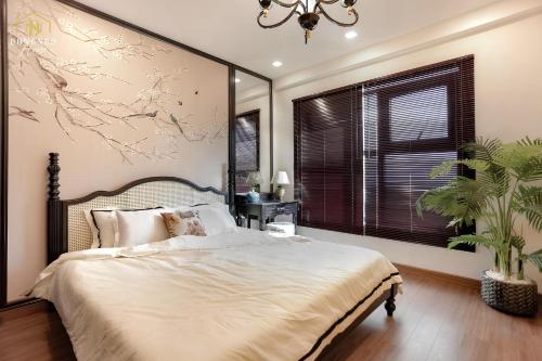 a bedroom with a large bed with a large painting on the wall at FLC Sea Tower Condotel in Quy Nhon