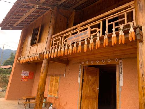 a building with a wooden balcony on top of it at Hoàng nam Homestay in Quang Ba