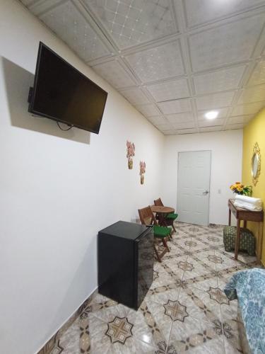 a living room with a flat screen tv on a wall at Belo Bay Apartment Hotel in Portobelo