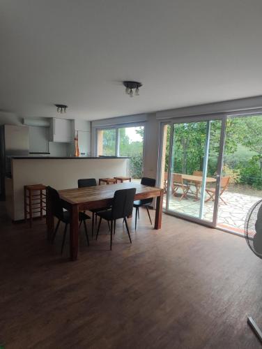 une salle à manger avec une table et des chaises en bois dans l'établissement Maison pour séjour en famille, à Montesquieu