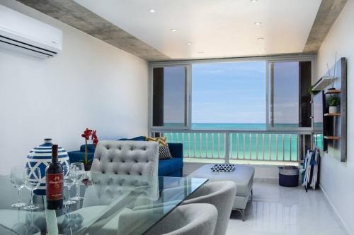 a living room with a glass table and chairs at Esperanza Beach 2BDR 2B Oceanfront Pool Parking in San Juan