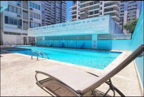 a swimming pool with a chair next to a building at Esperanza Beach 2BDR 2B Oceanfront Pool Parking in San Juan