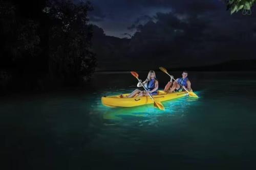 two people sitting on a yellow kayak in the water at Esperanza Beach 2BDR 2B Oceanfront Pool Parking in San Juan