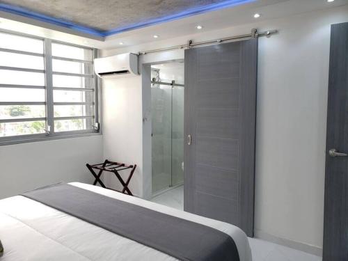 サンファンにあるEsperanza Beach 2BDR 2B Oceanfront Pool Parkingのベッドとガラスのシャワーを備えた寝室